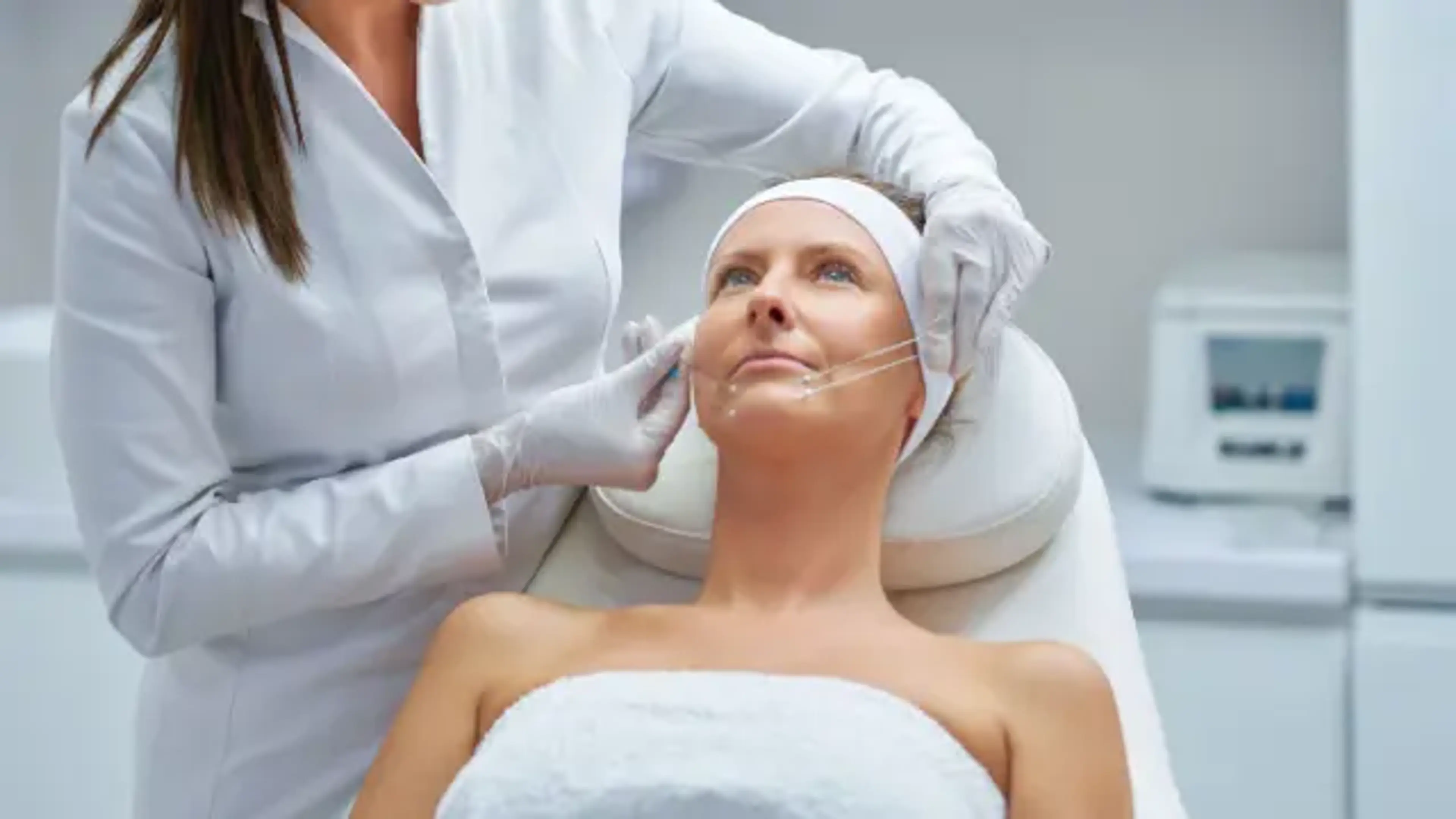 Doctor performing thread lift procedure to tighten and lift sagging facial skin