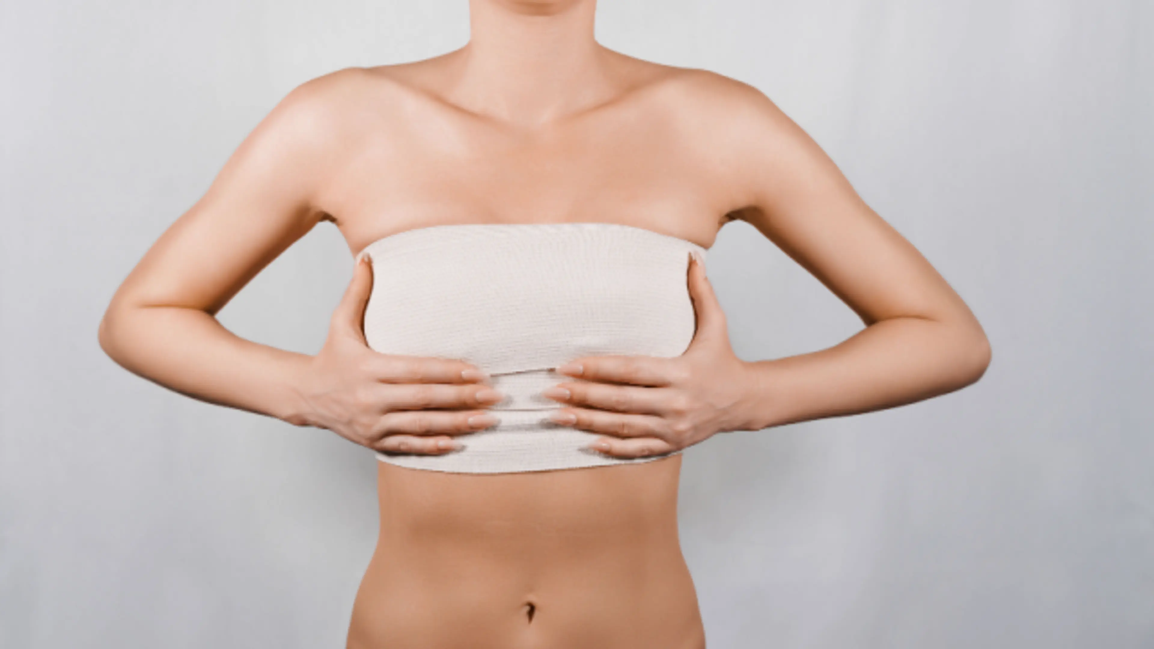Post-surgical chest compression band after breast augmentation procedure showing recovery and support garment