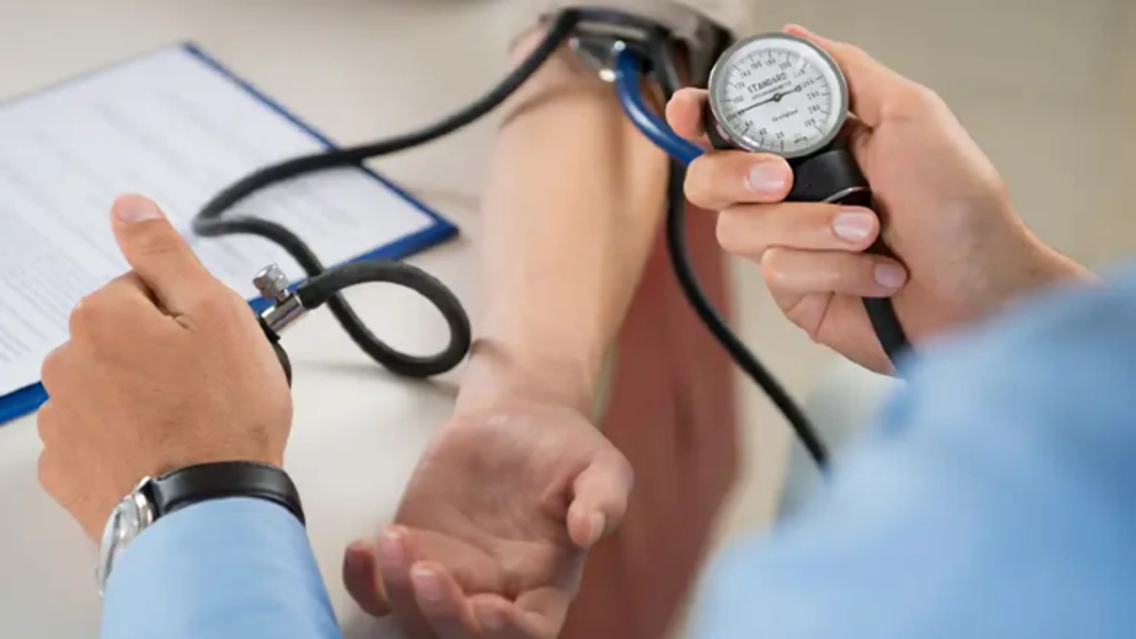 Doctor measuring a patient’s blood pressure with a sphygmomanometer during chronic disease management consultation