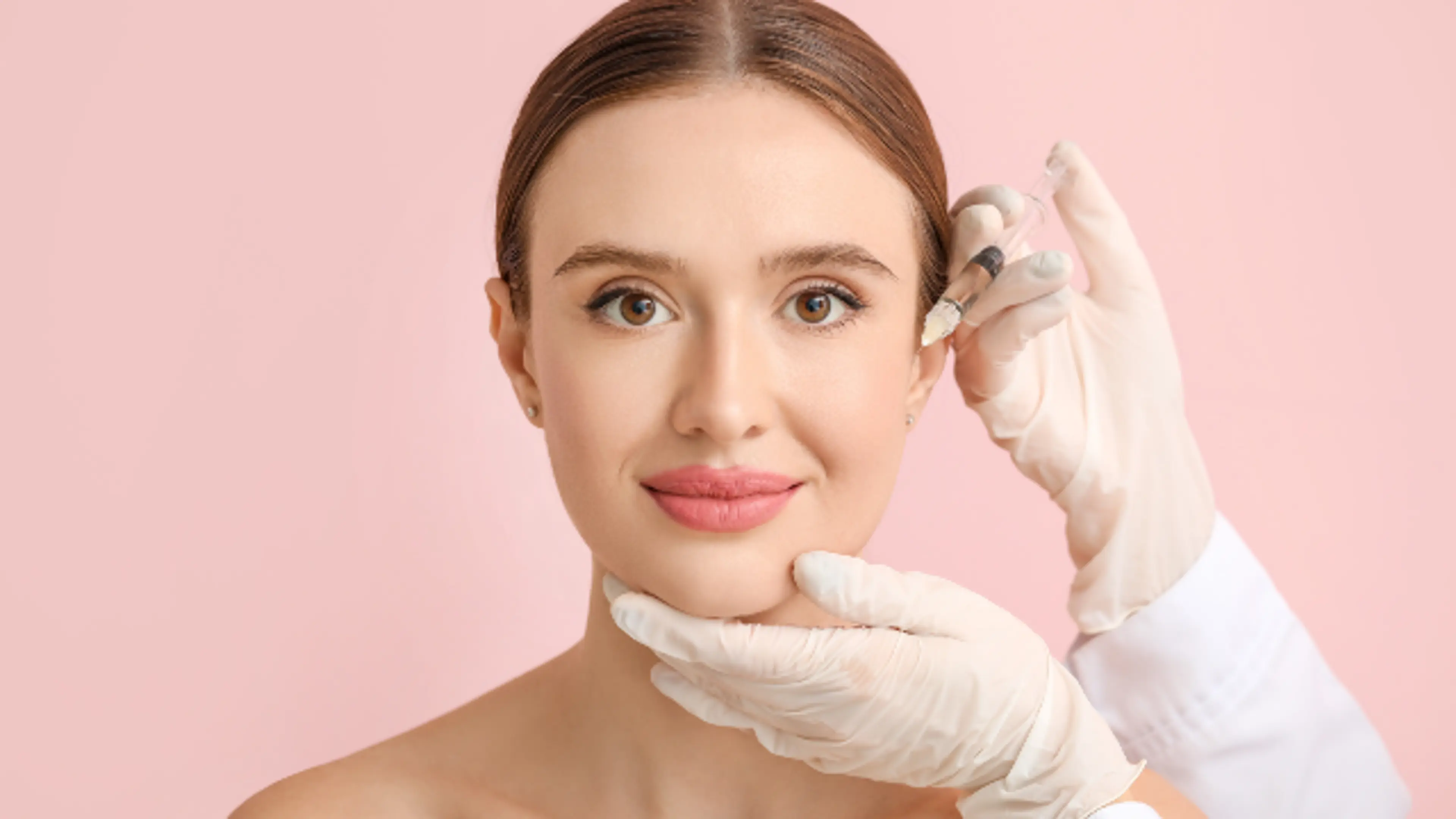 A mature woman undergoing a facial assessment; a doctor in white medical gloves points a black marker at the corner of her eye.