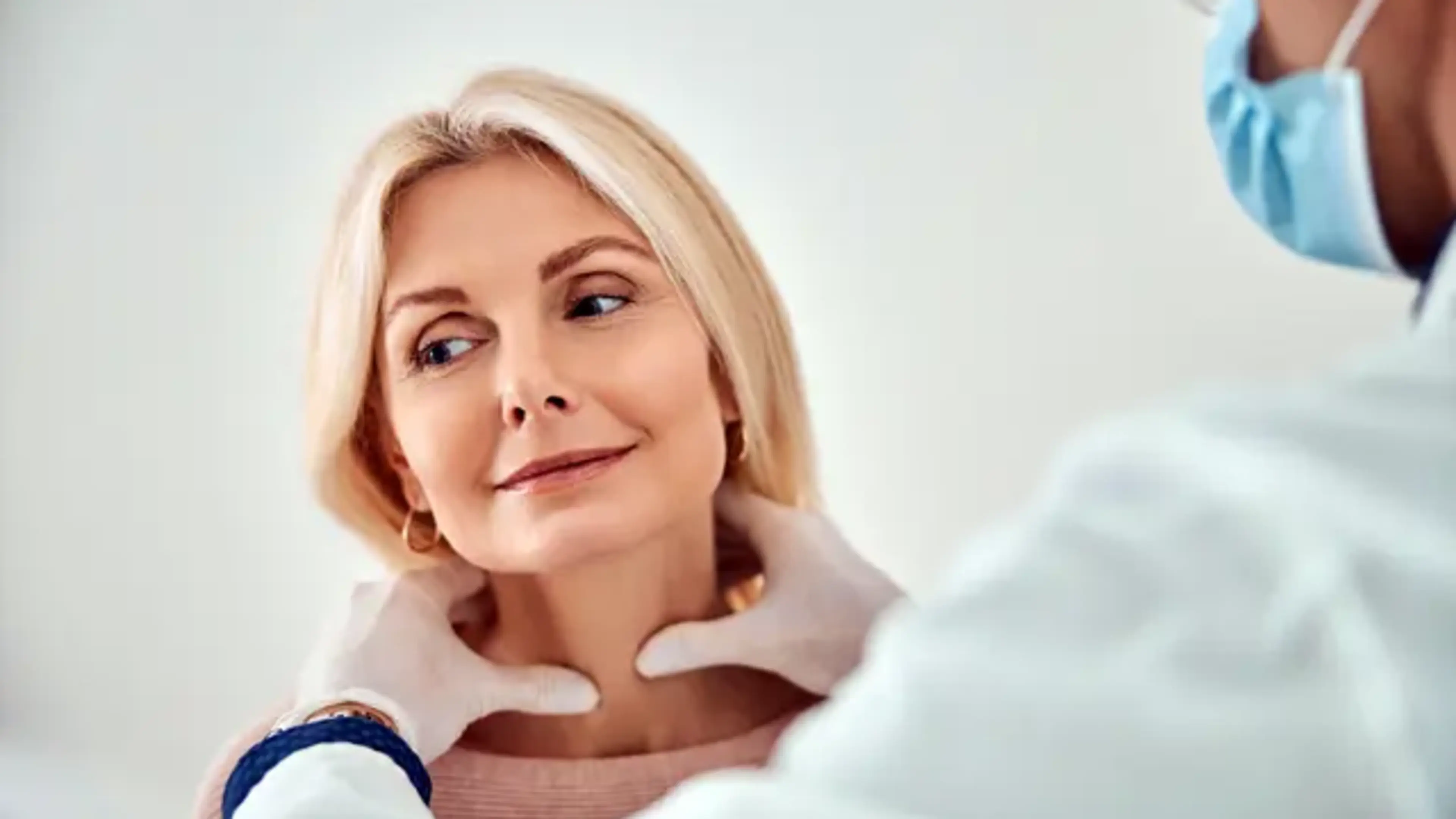 Doctor examining a female patient’s neck during a thyroid checkup at a general medicine thyroid clinic.
