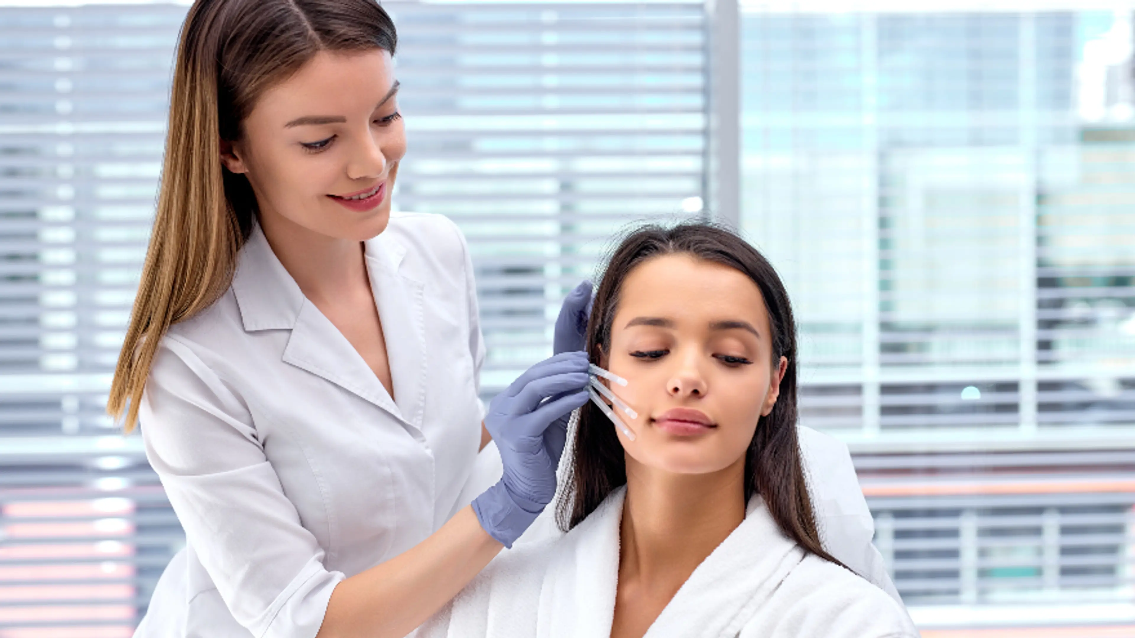 Doctor examining patient face for aesthetic treatment planning