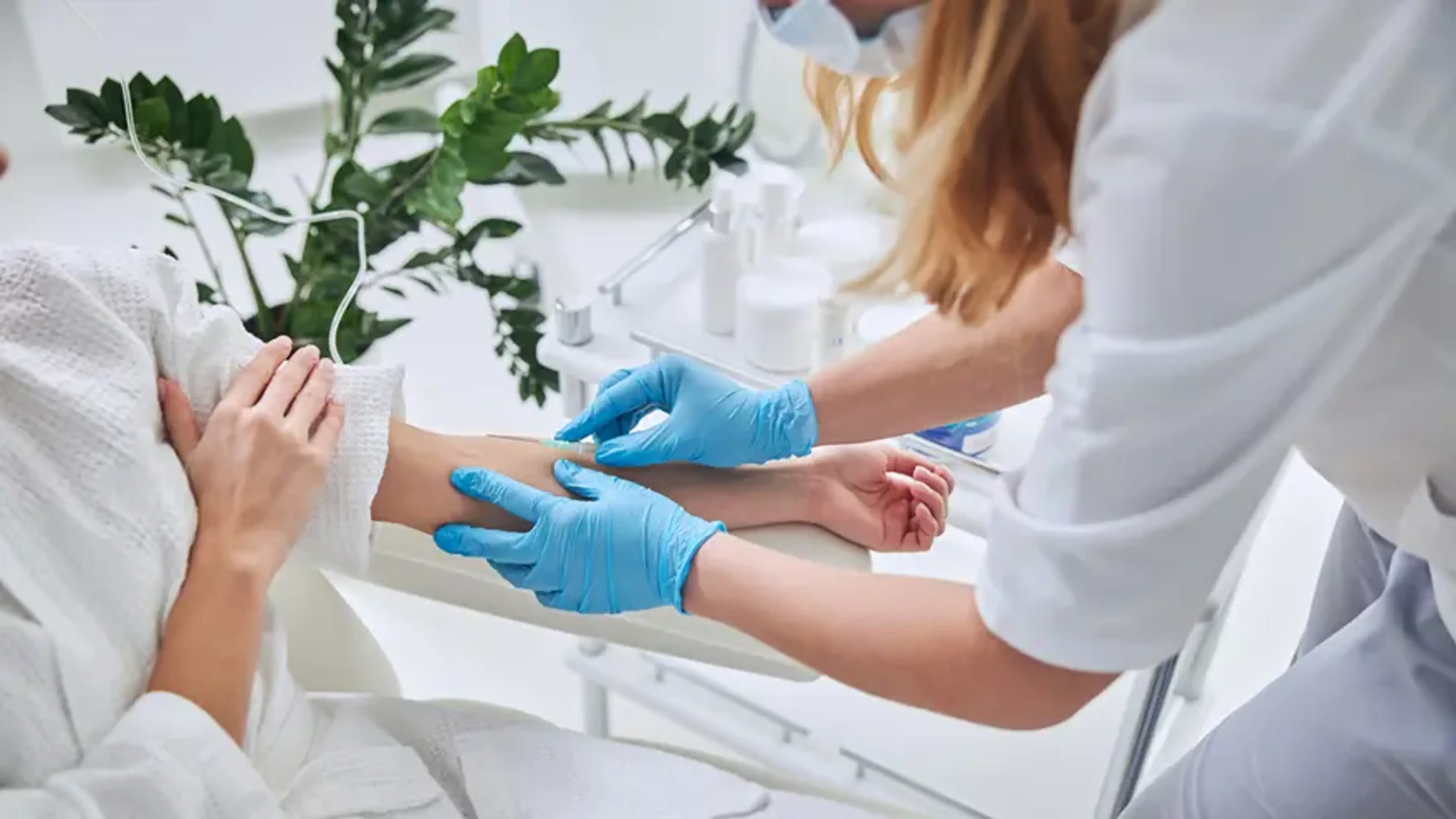 Nurse administering an intravenous vitamin injection to a patient’s arm during IV therapy clinic treatment.