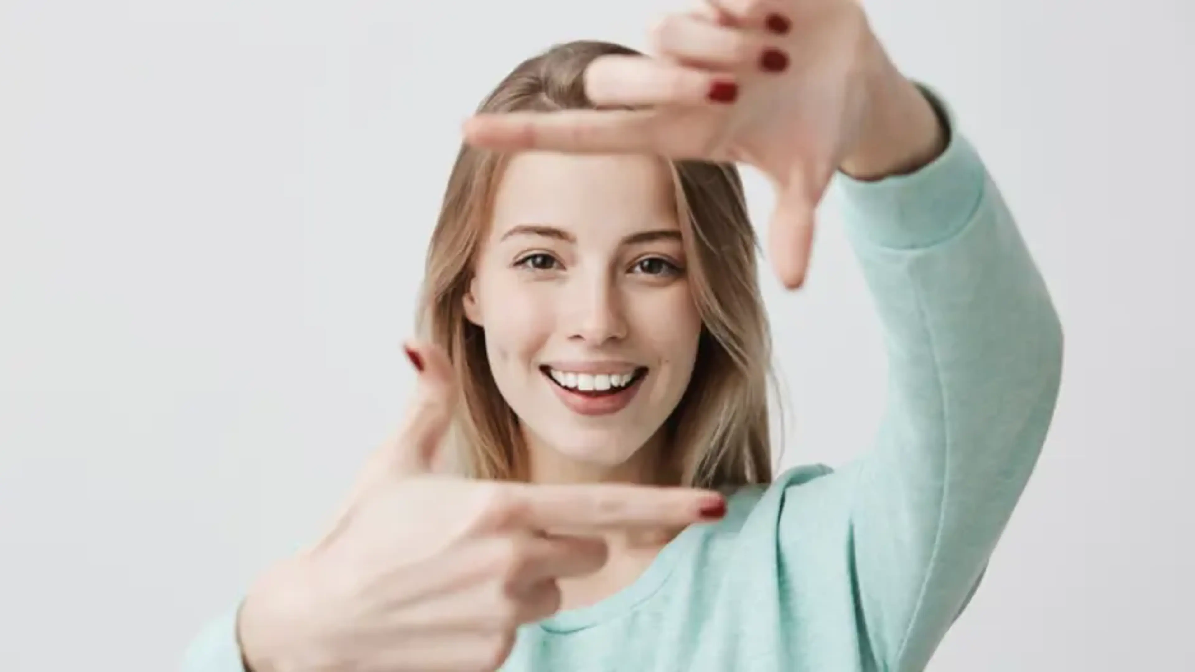 Smiling patient framing clear vision with hands representing freedom from glasses after LASIK and LASEK laser vision correction surgery